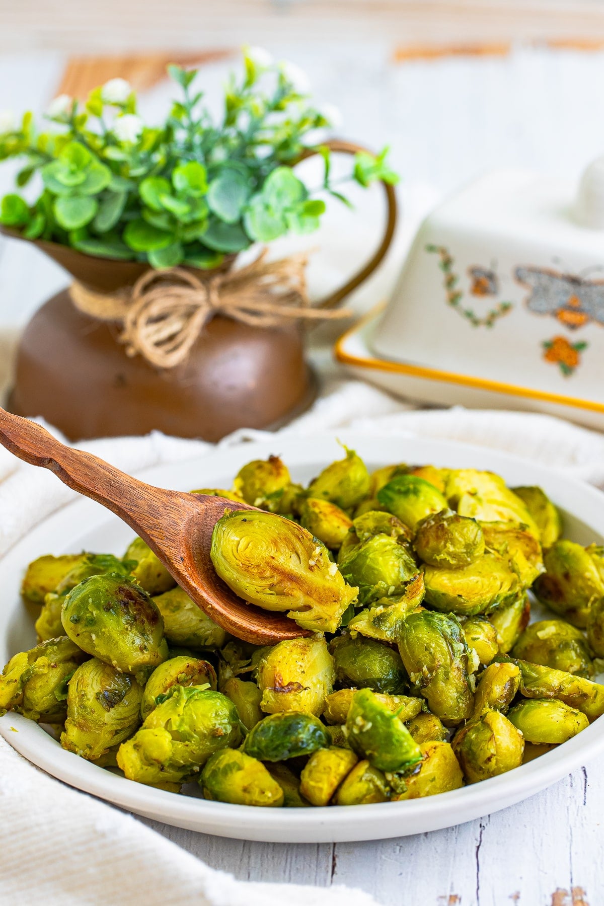 a spoon scooping out Brussels Sprouts in a Pan on a plate
