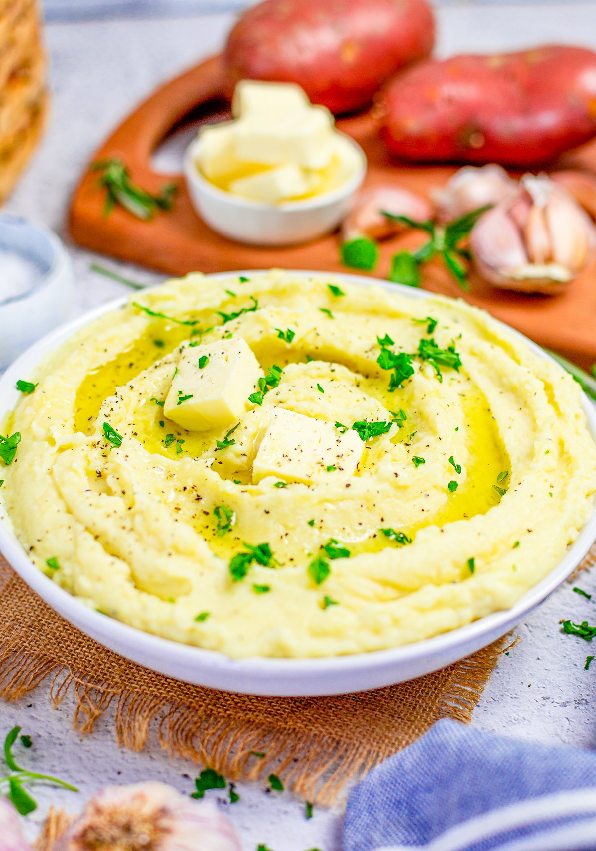 Serving bowl with Creamy mashed Potatoes with butter and parsley.