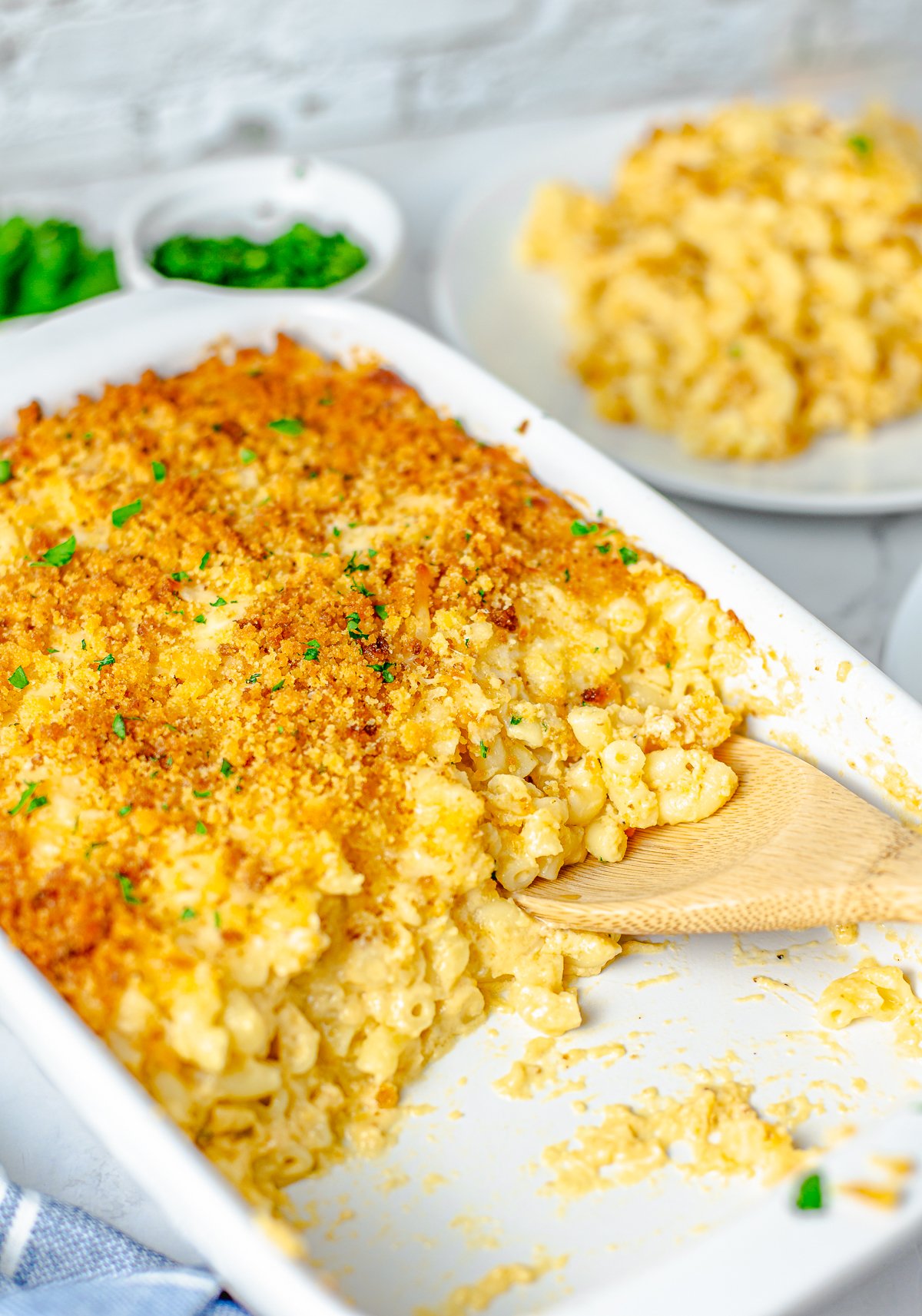 Baking pan with macaroni and cheese missing with wooden spoon.