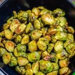 Easy Oven Roasted Brussel Sprouts Recipe served in a wooden bowl, halved sprouts roasted golden brown on the edges with crispy outer leaves and tender centers, ready to serve as a side dish.