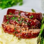 Three slices of Easy Meatloaf over mashed potatoes.
