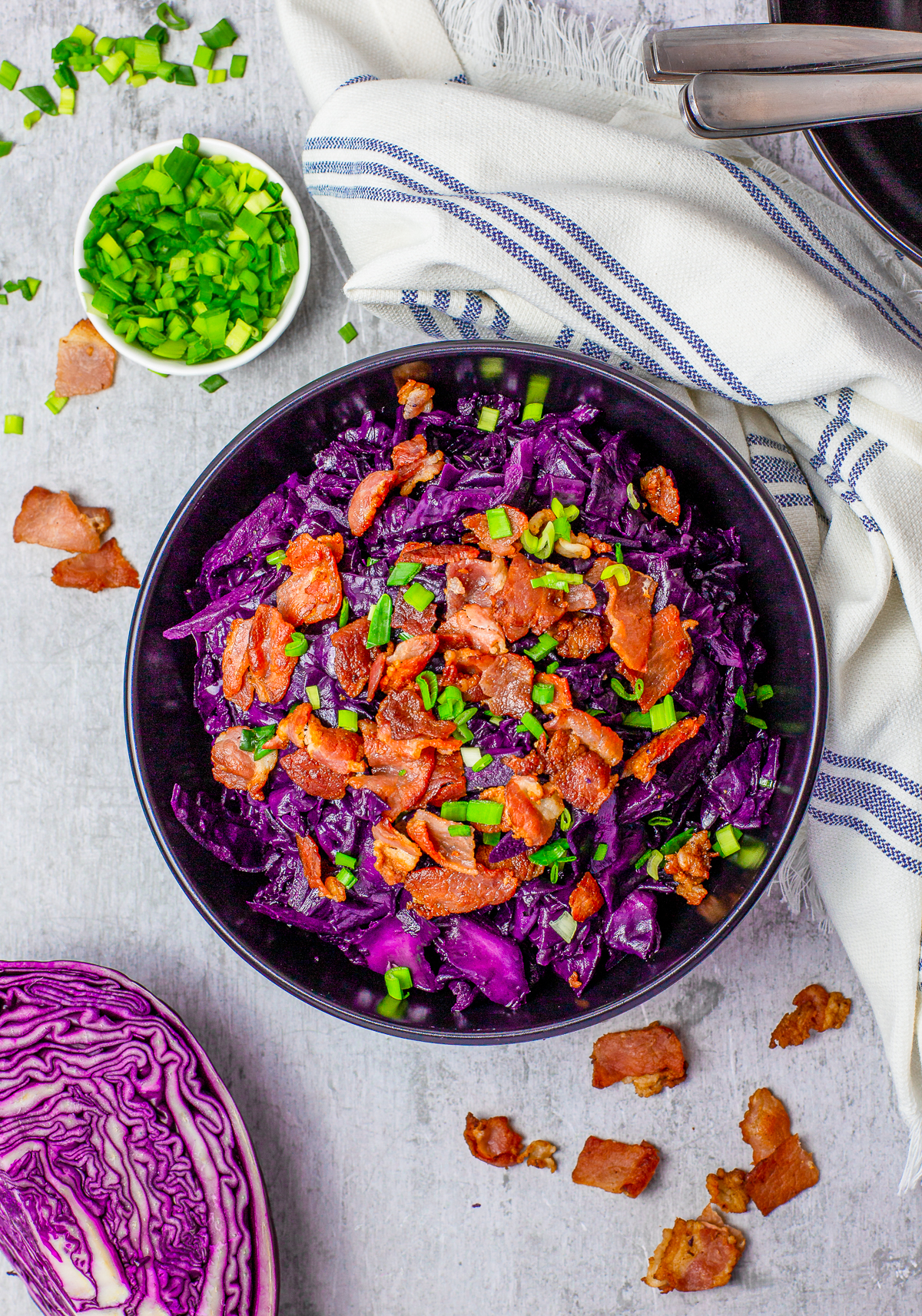 Overhead photo of Sweet and Sour Cabbage in bowl with bacon and scallionns.