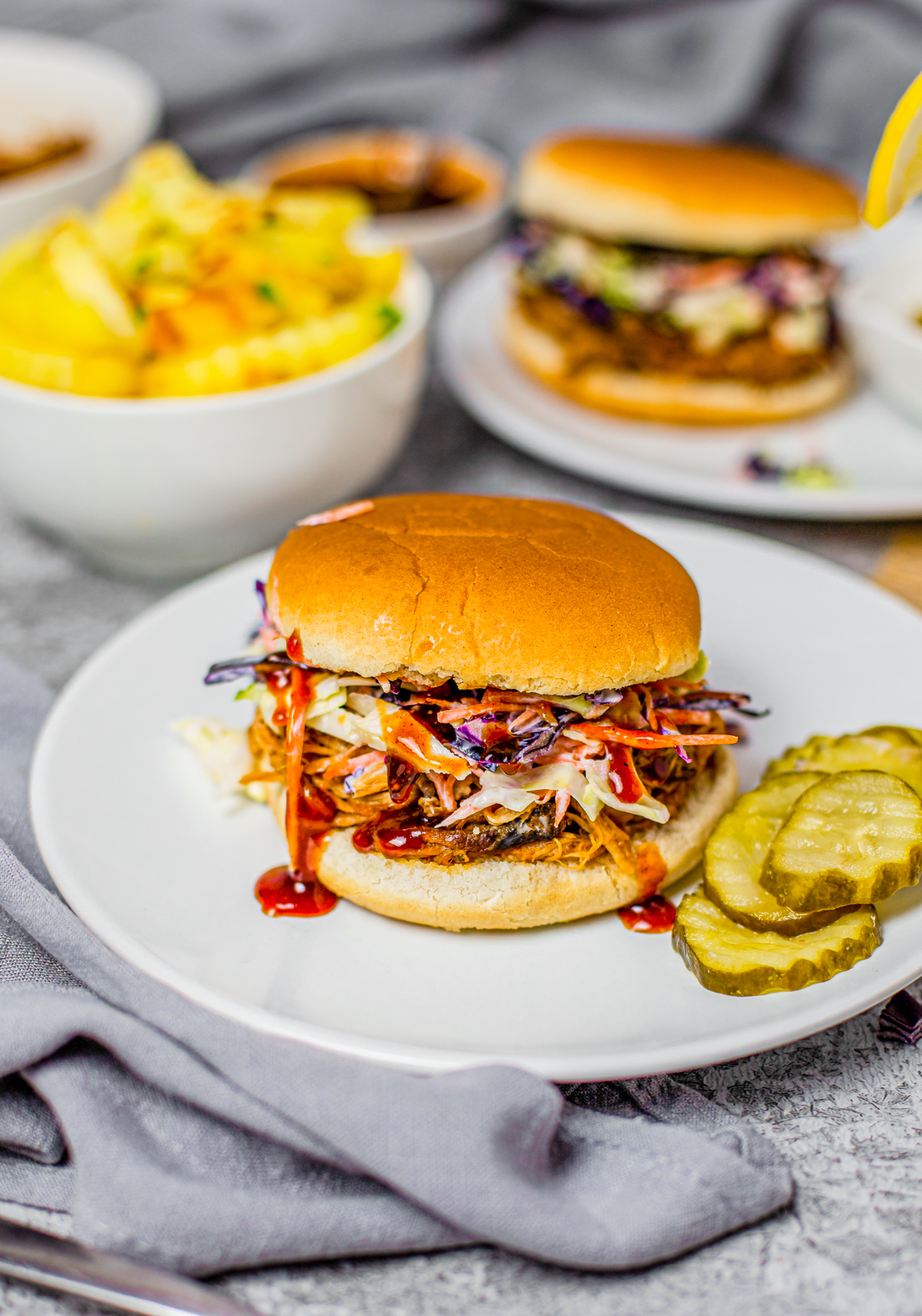 Crock Pot Pulled Pork Sandwich on white plate with pickles
