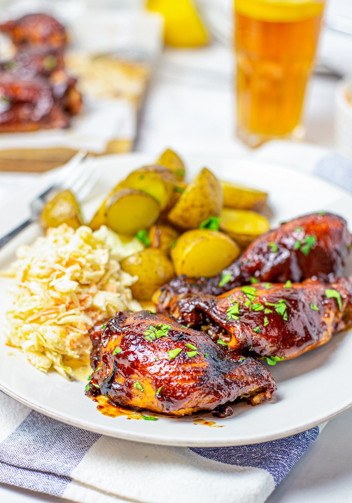 Serving plate of Sticky Slow Cooker BBQ Chicken with potatoes and coleslaw