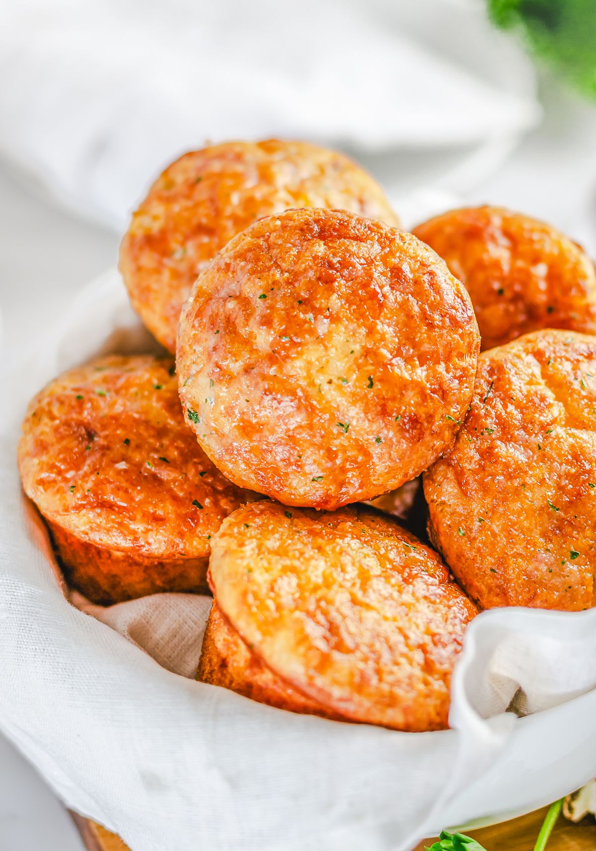 Golden stacked Garlic Cheese Muffins in basket.
