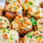 Sausage stuffed mushrooms with cream cheese baked golden brown and garnished with parsley.