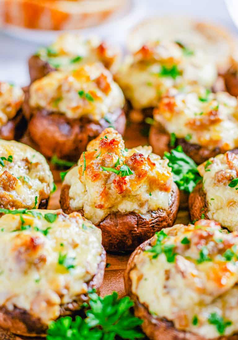 Sausage stuffed mushrooms with cream cheese baked golden brown and garnished with parsley.
