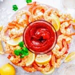 Overhead of Shrimp Cocktail Recipe on plate with lemons and cocktail sauce.