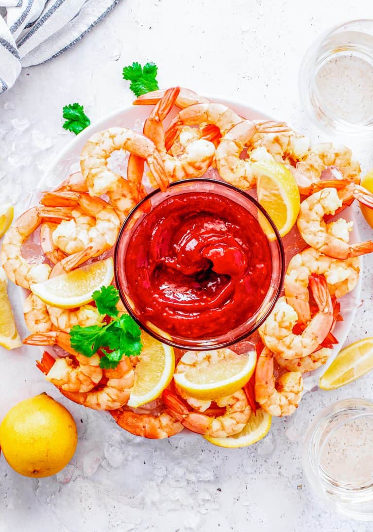 Overhead of Shrimp Cocktail Recipe on plate with lemons and cocktail sauce.