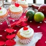 Cherry Cupcakes topped with whipped lime frosting, a maraschino cherry, and fresh lime zest.
