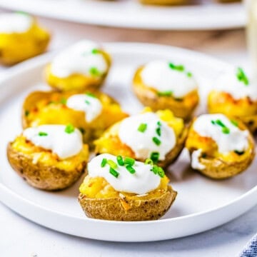 Square image of finished potatoes on plate, garnished.