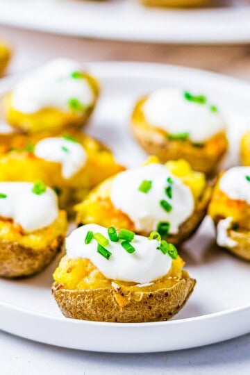 Square image of finished potatoes on plate, garnished.