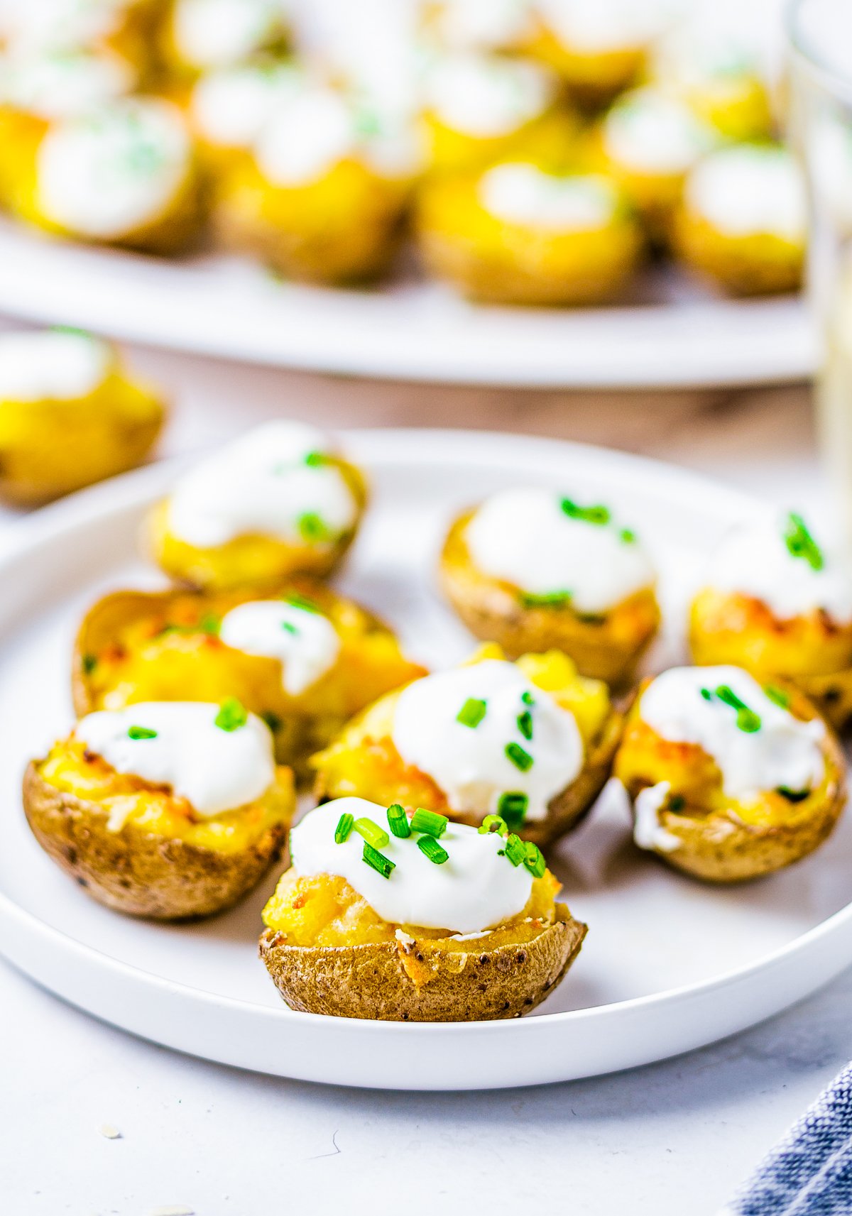Parmesan Potatoes on plate topped with sour cream and chives. 