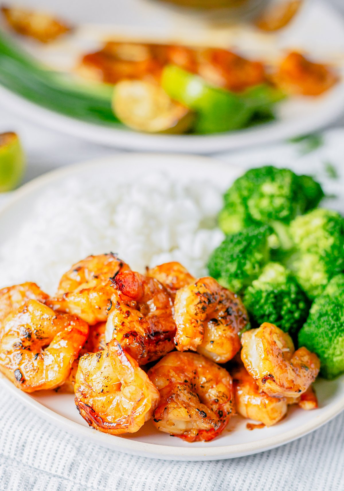 Shrimp off skewer on plate with rice and broccoli