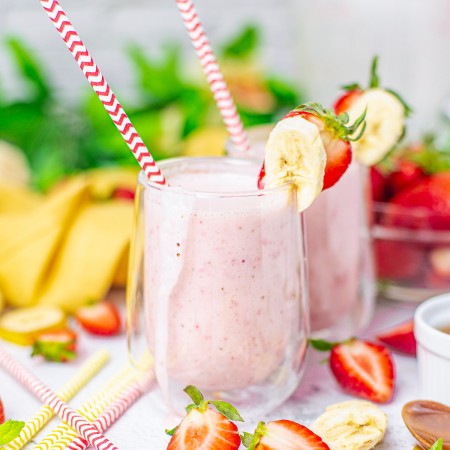 Square image of two smoothies with straws and fruit