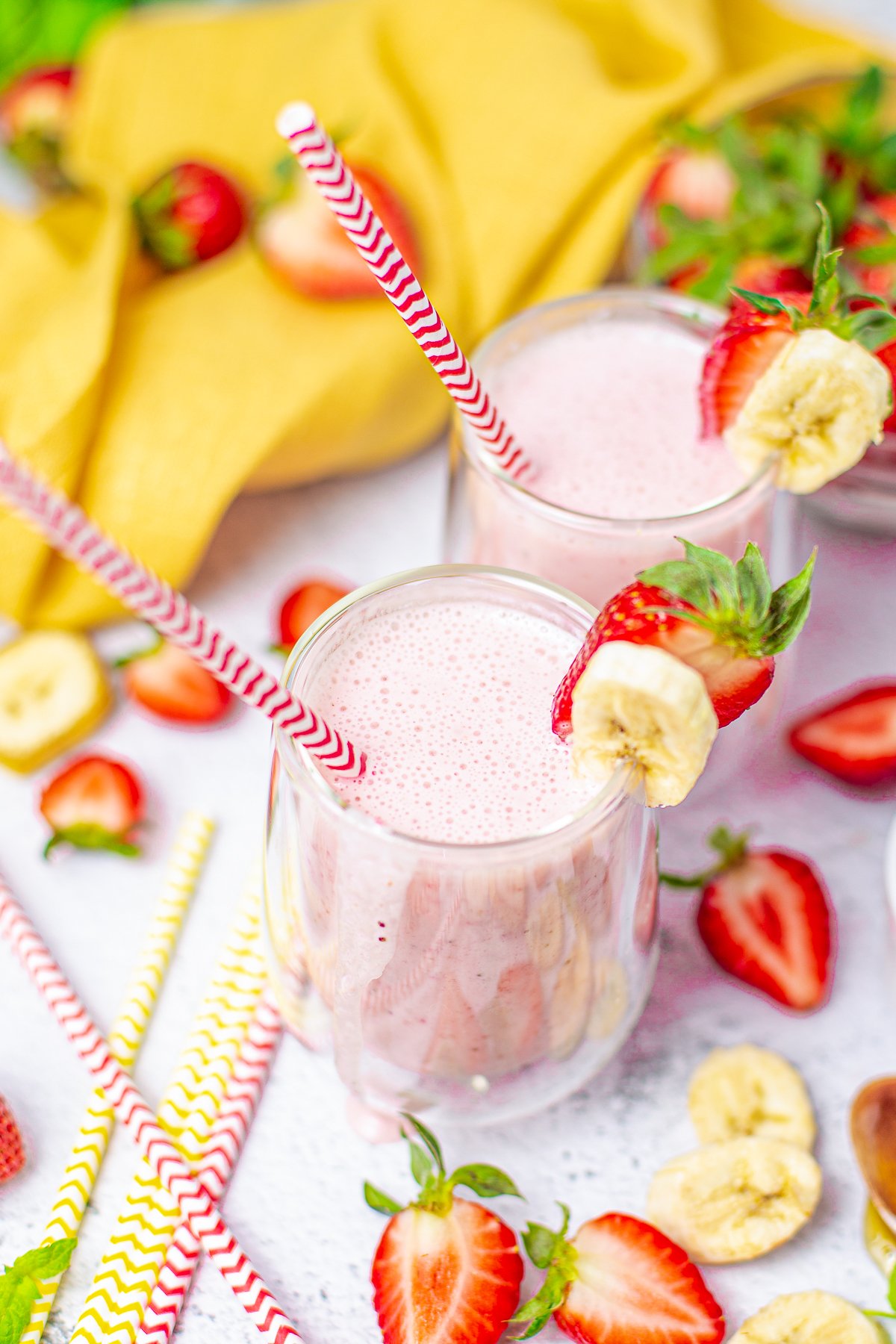 Sightly overhead photo of two smoothies garnish with bananas and strawberry slices