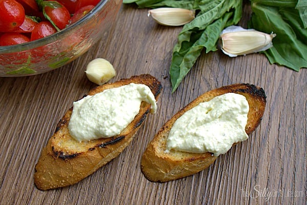 Bruschetta with Whipped Feta and Grilled Crostini, grilled baguette smeared with creamy whipped feta spread and topped with fresh grape tomatoes marinated in a sweet and tangy basil vinaigrette. 