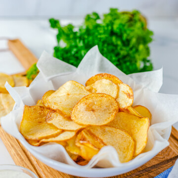 Finished Homemade Potato Chips in basket with parchment paper.
