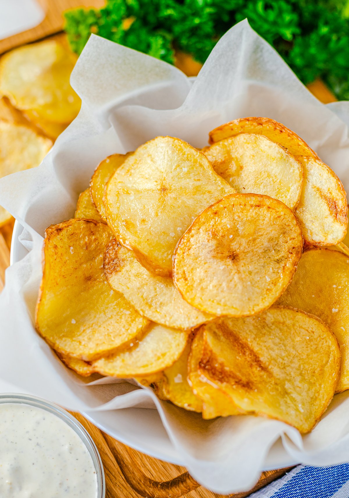 Overhead of Potato Chips in basket with dipping sauce in basket.