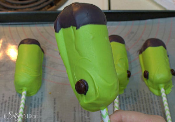 Taking two brown M&M's per twinkie, place a little dot of melted black candiquick on the side with the "M" and place on the lower 1/4th of the Twinkie by the stick for the bolts on Frankenstein's neck. 