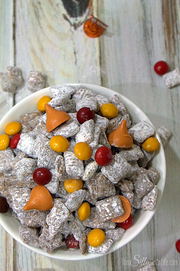 Pumpkin Patch Munch, traditional muddy buddies dusted with pumpkin pie spice powdered sugar and loaded with peanut butter m&m's and pumpkin spice kisses! - https://ThisSillyGirlsLife.com