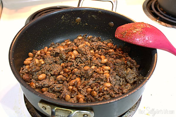 Preheat oven to 400 degrees. Brown ground beef over medium heat in skillet. Drain fat, add in the pinto beans and seasonings for the taco meat. Mix and let the seasonings coat the meat and cook until fragrant about 30 seconds.
