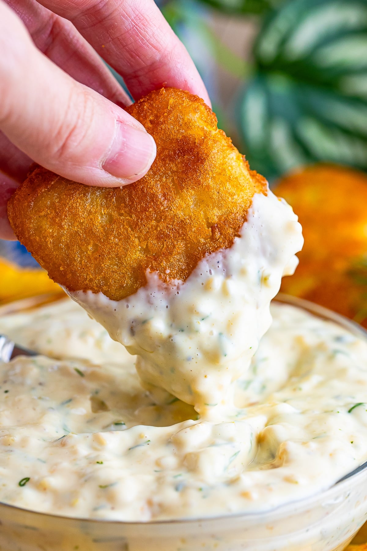 a piece being dipped into easy tartar sauce