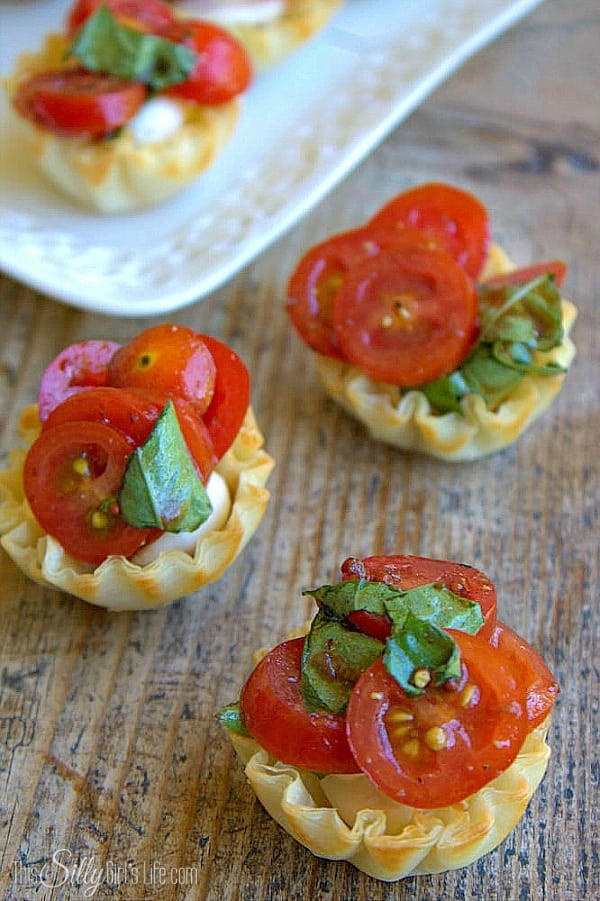 Creamy Bruschetta Bites, Parmesan cream cheese piped into phyllo cups and topped with tomato basil bruschetta! - ThisSillyGirlsLife.com