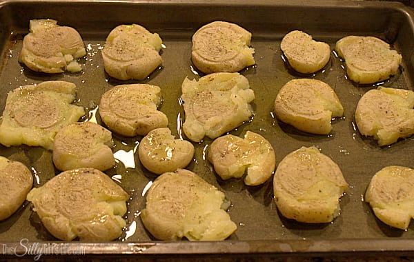Place potatoes onto sheet tray and with the bottom of a glass, smash them until about 1/2 inch or the thickness of your index finger. Drizzle with the olive oil