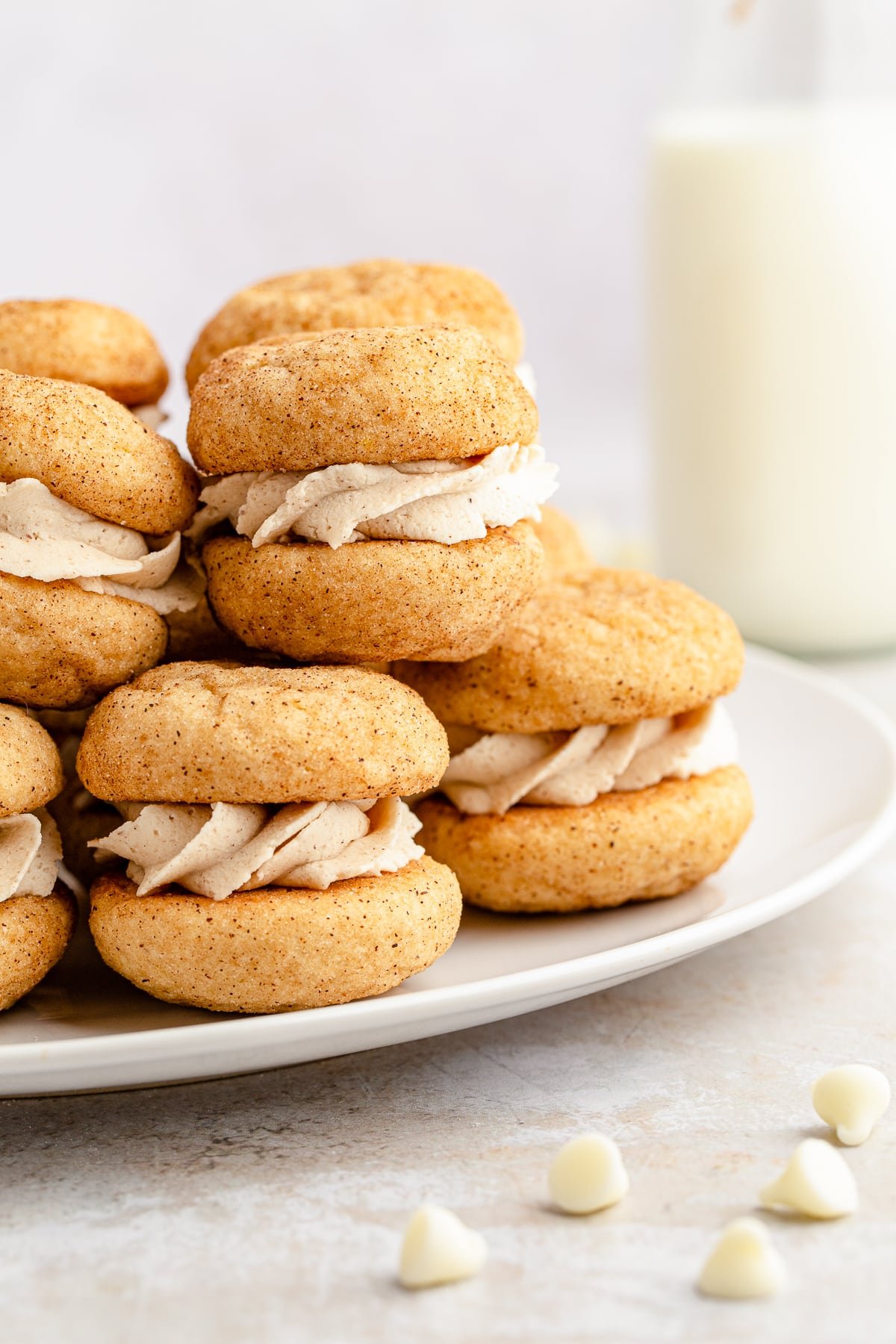 Close up side view of Snickerdoodle Sandwich Cookies stacked on white plate.