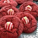Red velvet blossom cookies with striped candy cane Hershey kisses pressed into the centers.