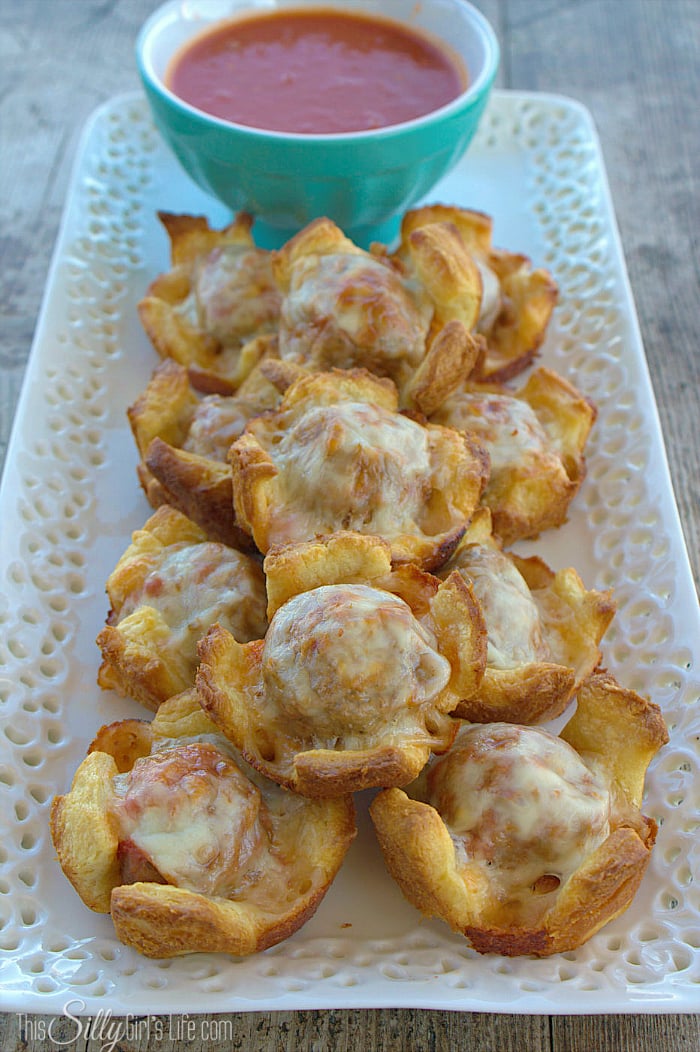 Meatball Sub Cups, meatballs and provolone cheese baked in crescent roll cups. Served with tomato sauce, a great party appetizer, yum! - ThisSillyGirlsLife.com #MancinisMeatballs #ad