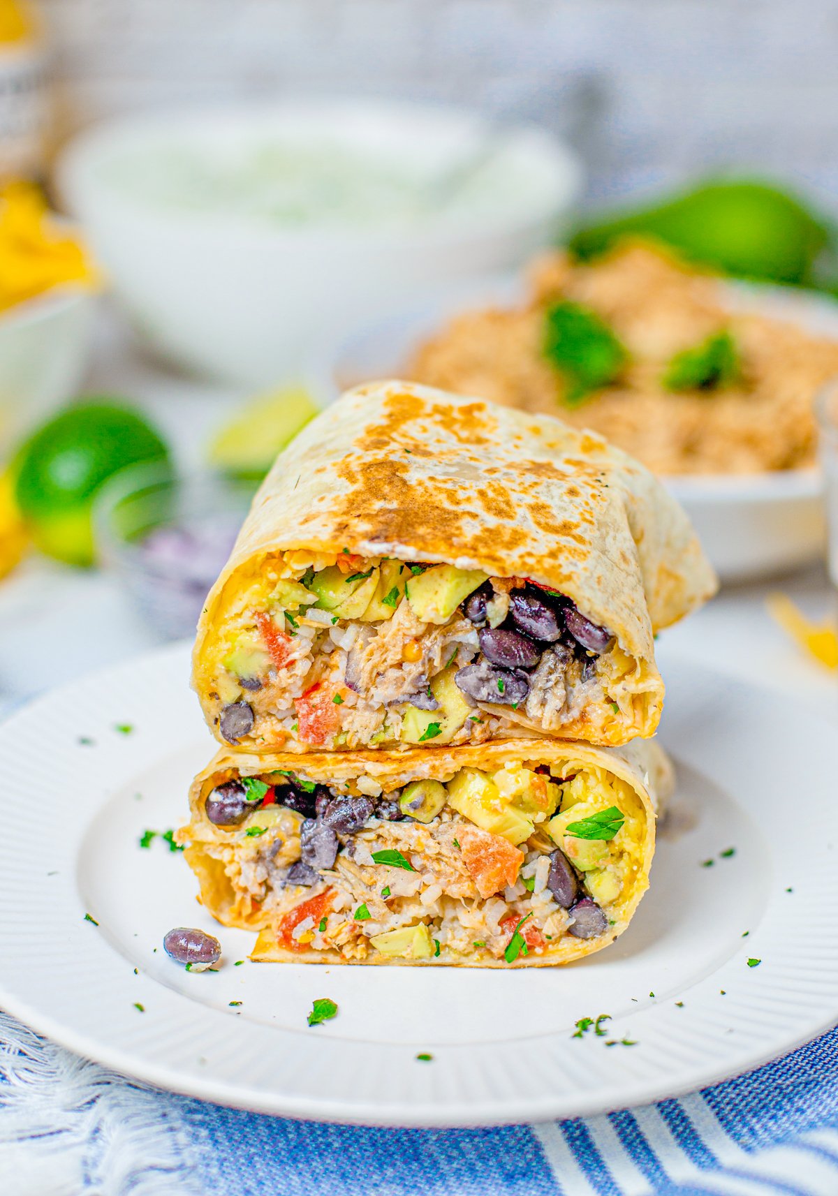 One Slow Cooker Chicken Burrito cut in half stacked on plate