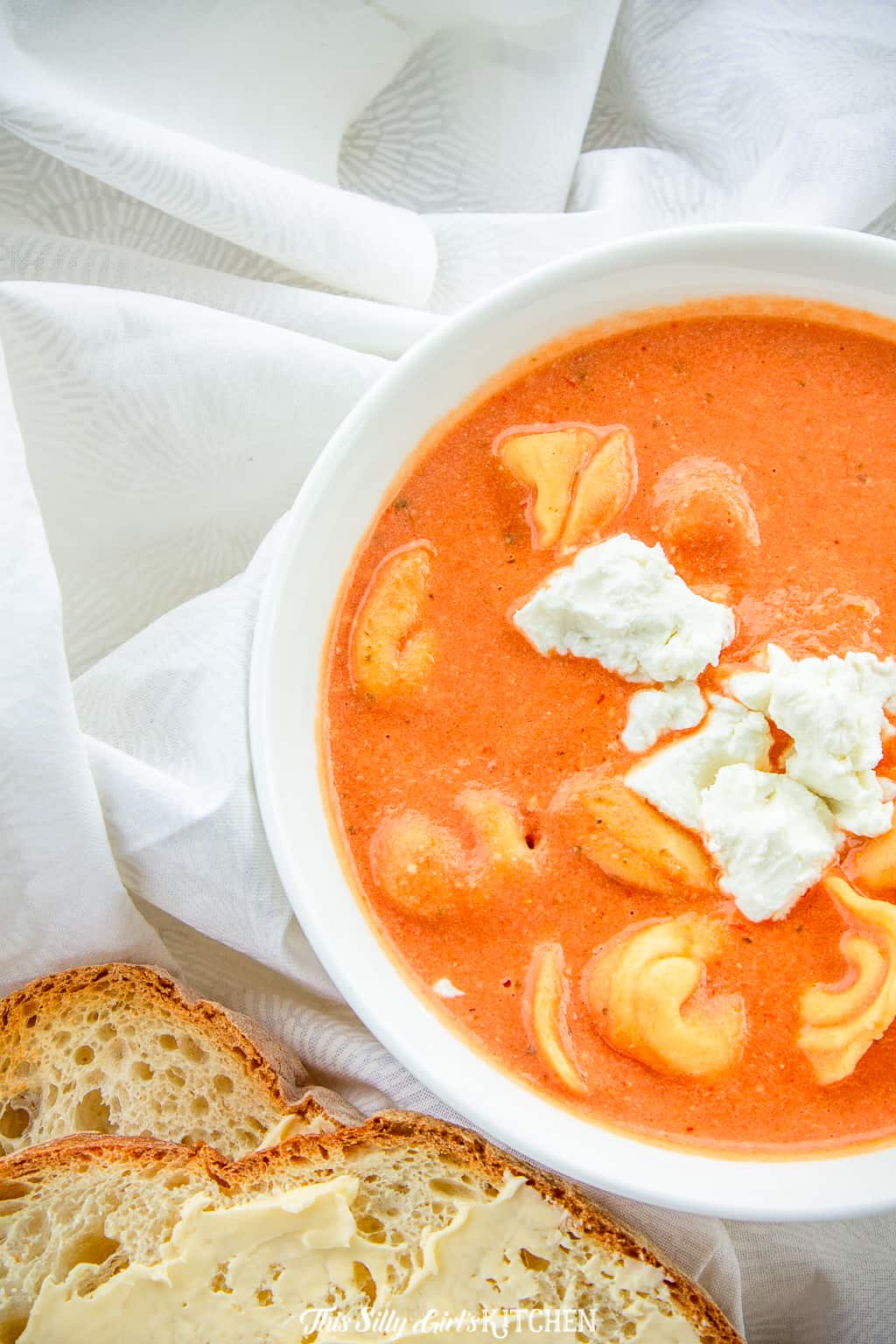Bowl of tomato soup topped with cheese