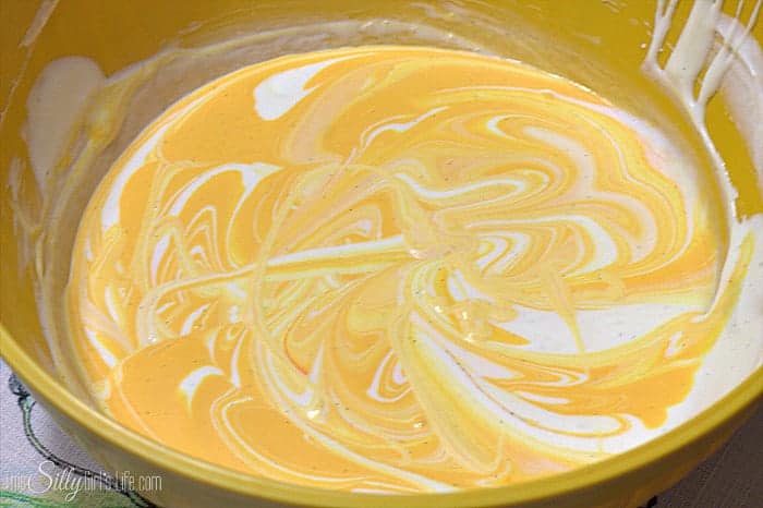Orange tinted filling swirled into the cream cheese mixture for Orange Creamsicle Pie.