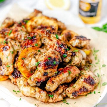 A platter of sticky grilled chicken wings with lemon and herbs.