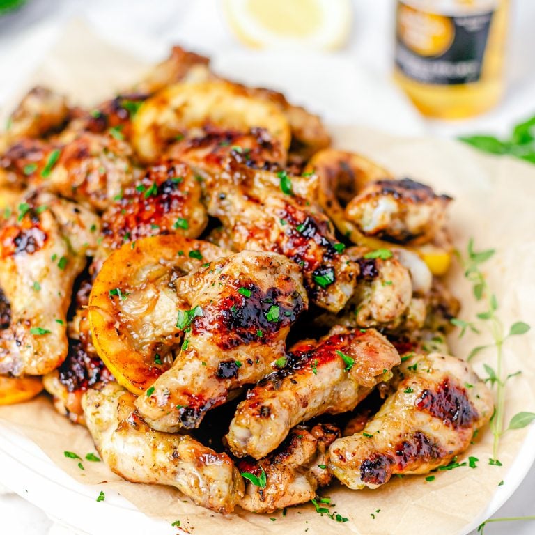 Square image close up of Grilled Chicken wings on white platter