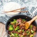 Best Beef and Broccoli Marinade Recipe served over white rice in a white bowl with chopsticks.