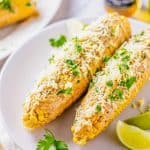 Two ears of corn garnished on white plate
