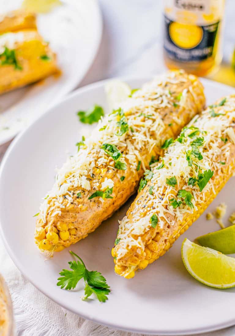 Two ears of corn garnished on white plate