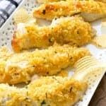 Baked potato chip chicken tenders with a golden crushed chip crust arranged on a white platter.