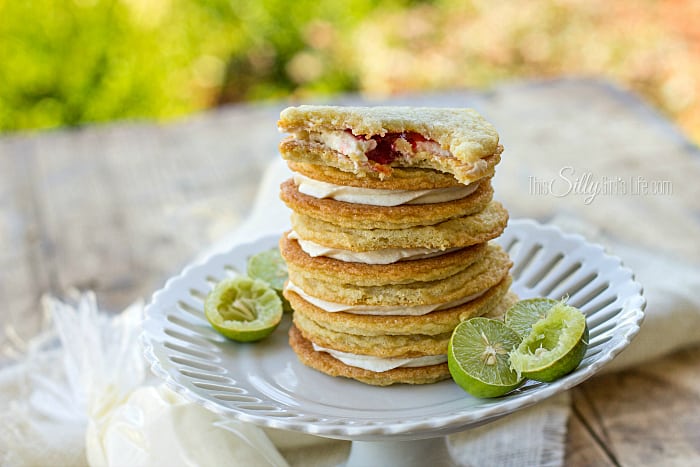 Key Lime Raspberry Sandwich Cookies, raspberry curd and key lime frosting sandwiched between two soft and chewy sugar cookies! Plus video tutorial. - ThisSillyGirlsLife.com #chewysugarcookies #sandwichcookies #keylime #raspberry