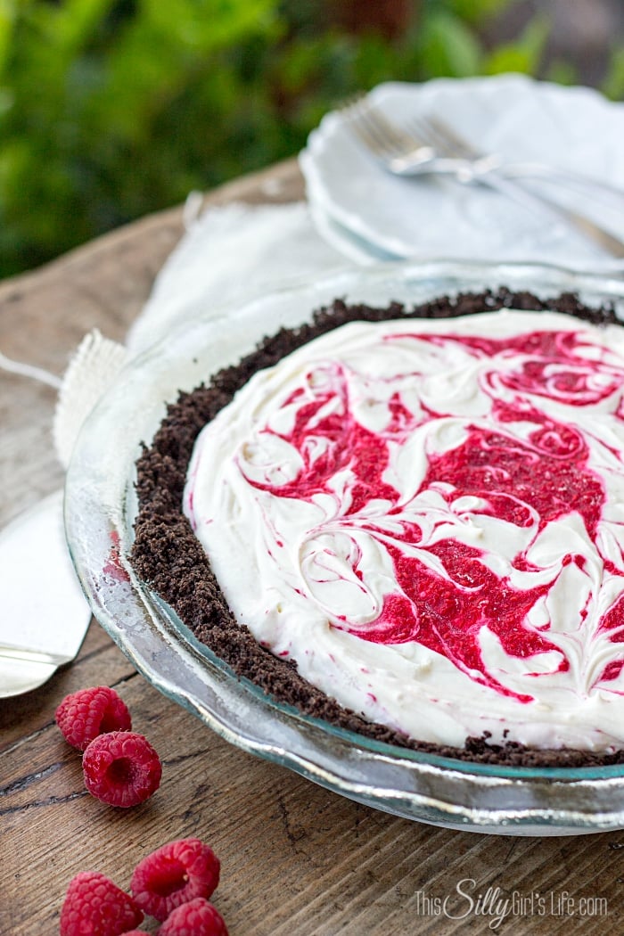 No Bake White Chocolate Raspberry Cheesecake, a frozen, decadent version of a classic cheesecake. With Oreo cookie crust! - ThisSillyGirlsLife.com #OreoCrust #WhiteChocolateRaspberryCheesecake #Cheesecake #NoBake #NoBakeCheesecake