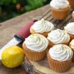 Frosted Lemon Lime Angel Food Cupcakes on a wood board with a lemon.