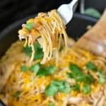 Skillet of one pan BBQ chicken pasta topped with shredded cheese and fresh cilantro