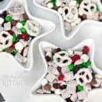 Star shaped bowls filled with Christmas Trail Mix with muddy buddies, holiday candies, pretzels, and marshmallows.