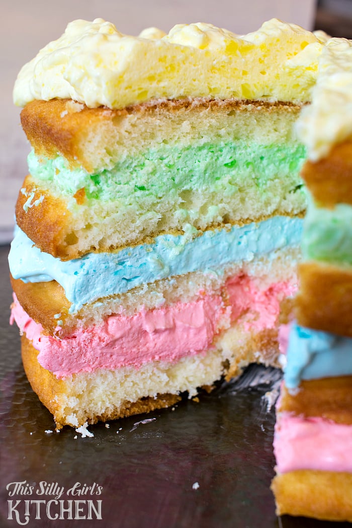 Rainbow Jello Cloud Cake, white cake layered between different flavors of light and airy Jello frosting! from ThisSillyGirlsLife.com #jellofrosting