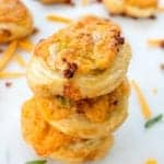 A stack of golden baked bacon ranch pinwheels with flaky puff pastry layers and melted cheddar.