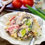 Steak Potato Salad plated with grilled potatoes, blackened flank steak, tomatoes, and bleu cheese.