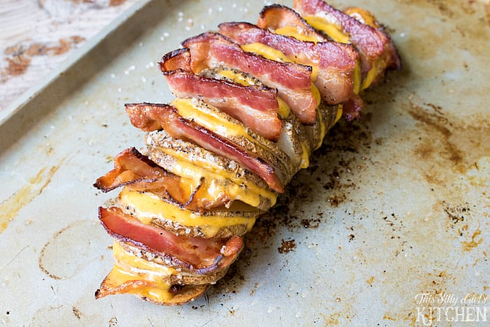 Fully Loaded Hasselback Potatoes, russet potatoes cut and baked until crispy, loaded with cheese and bacon, topped with all the fixings! from ThisSillyGirlsLife.com #JimmyDeanBacon #ad